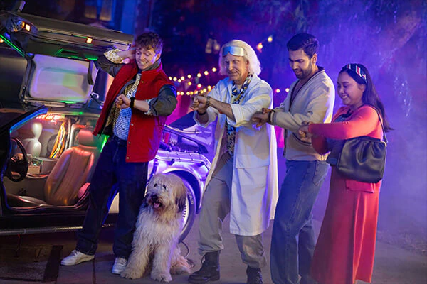 Guests posing with two cosplay actors dressed as Marty McFly and Dr. Emmett Brown from Back to the Future during Universal Fan Fest Nights.