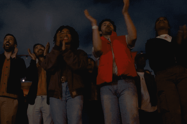 A GIF featuring people posing for photos and cheering as they watch fireworks during Universal Fan Fest Nights.
