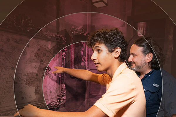 An image of father and son trying to solve their way out of a pirate themed escape room with a circle design overlay.
