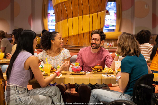 A group of friends sitting at a table enjoying food and drinks at Toadstool Cafe.