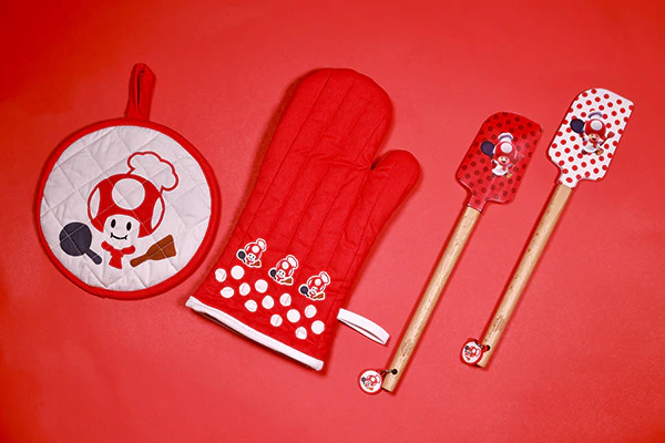 A pot holder, oven mitt and two spatulas featuring the character Toad with a red a white design.