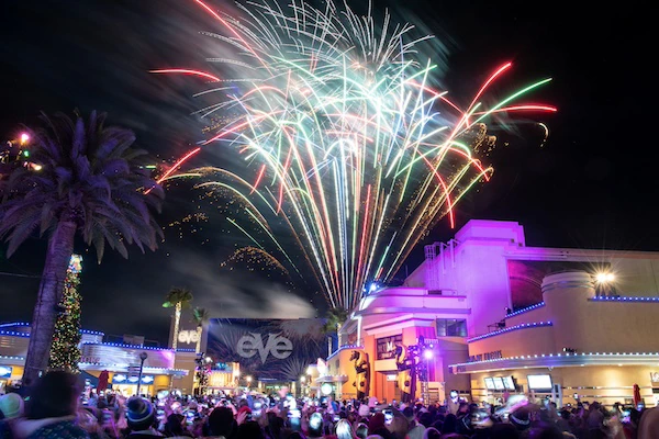 A crowd watches fireworks at Universal Studios Hollywood EVE celebration.