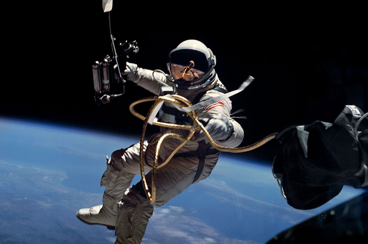 NASA astronaut performing a spacewalk while tethered. The Earth is visible in the background.