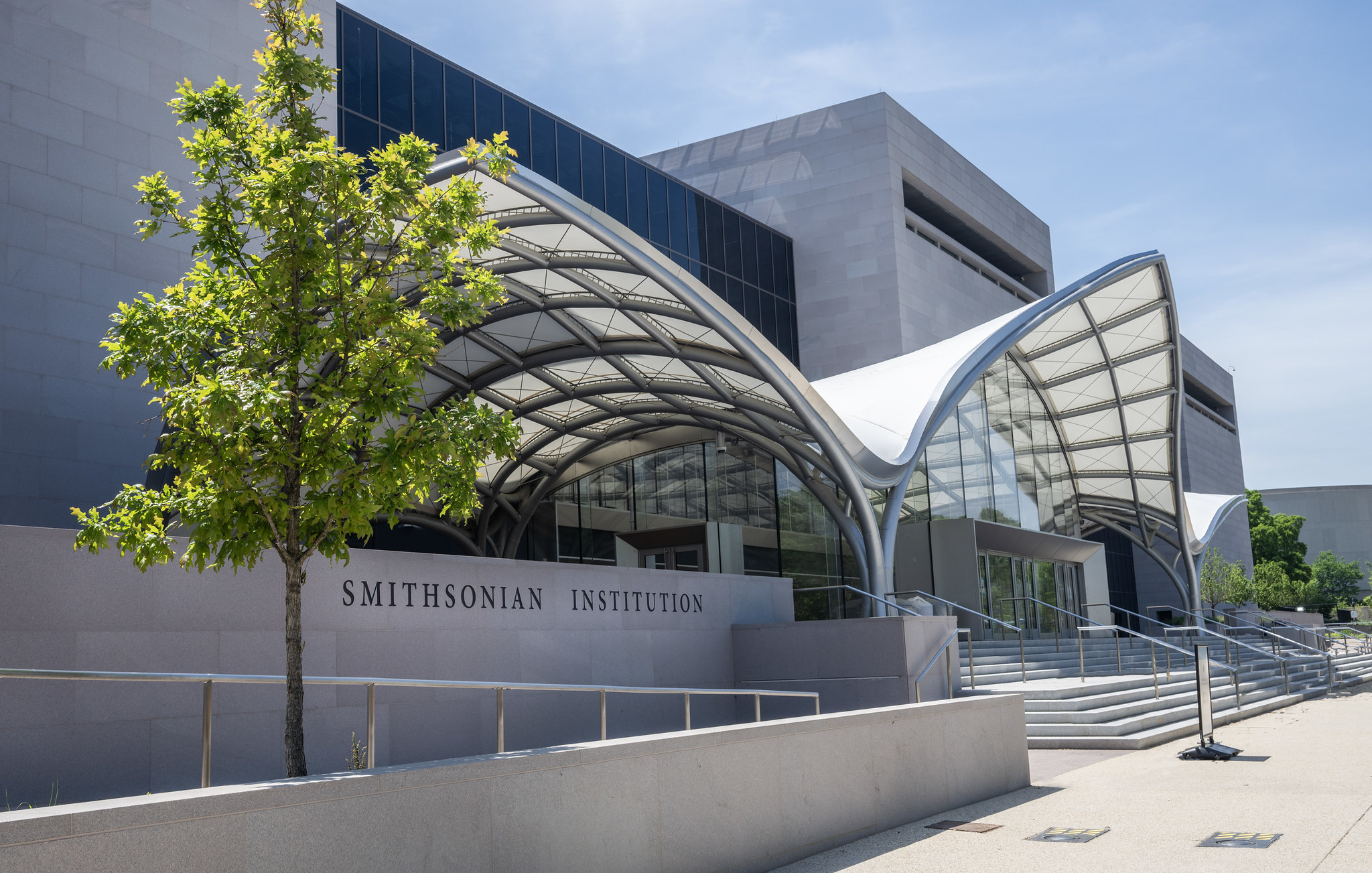 The entrance of a museum featuring a vestibule and trees.