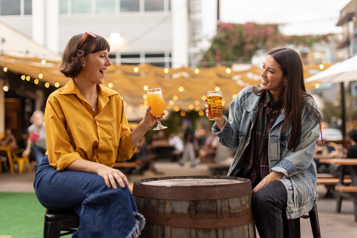 Friends sipping drinks outdoors at Zilker Brewing, Austin, Texas