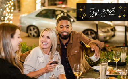 People enjoying wine and a meal at Austin's 2nd Street District