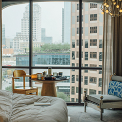 A guest room at The LINE Austin hotel with floor-to-ceiling window views of the city skyline