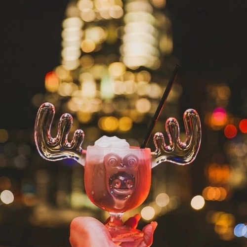 A holiday-themed drink served in a glass shaped like a moose head with antlers at the Azul rooftop in Austin, Texas