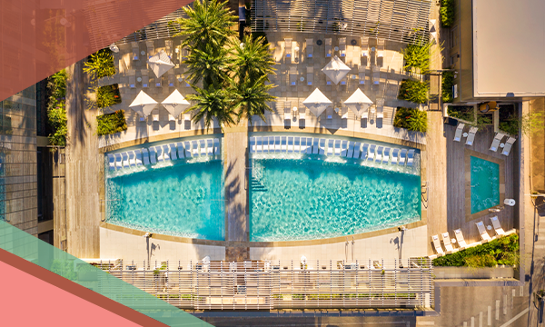 Overhead view of rooftop pool, deck, lounge chairs and palm trees at the Fairmont Austin hotel in Downtown Austin, Texas