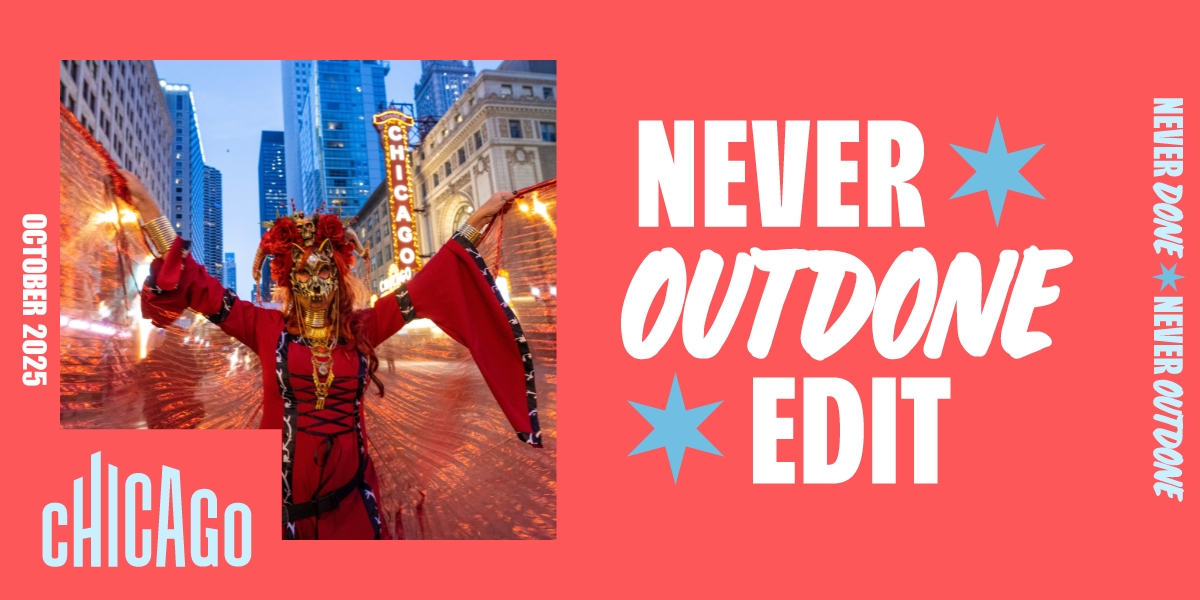 A colorfully costumed performer from the nighttime Arts in the Dark parade stands in front of the brightly lit Chicago Theatre marquee