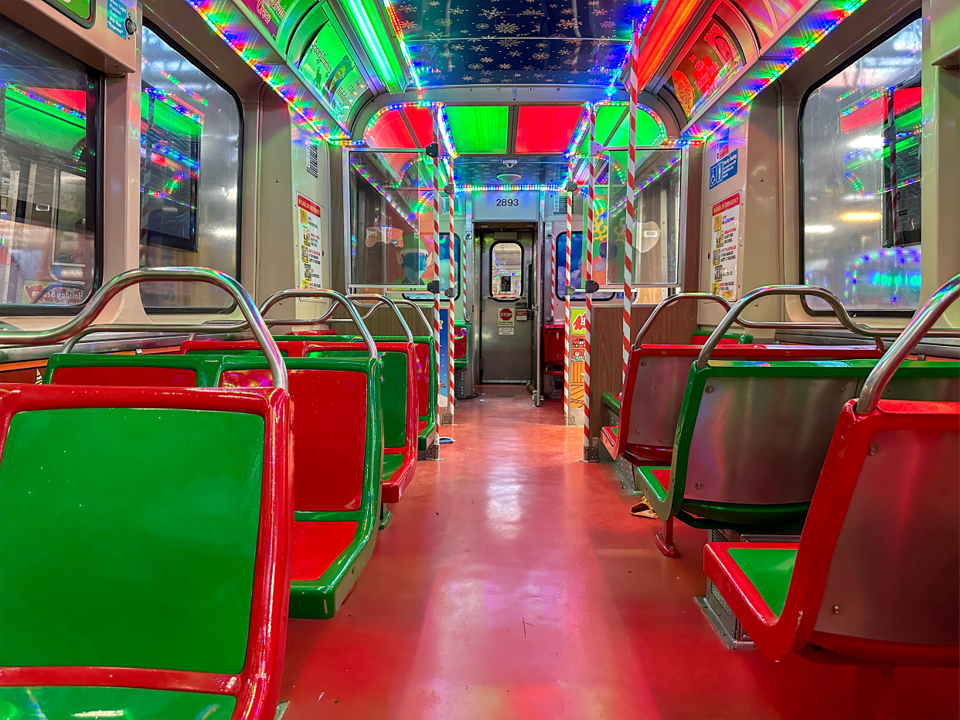 A CTA holiday train decorated with red-and-green seating and lights