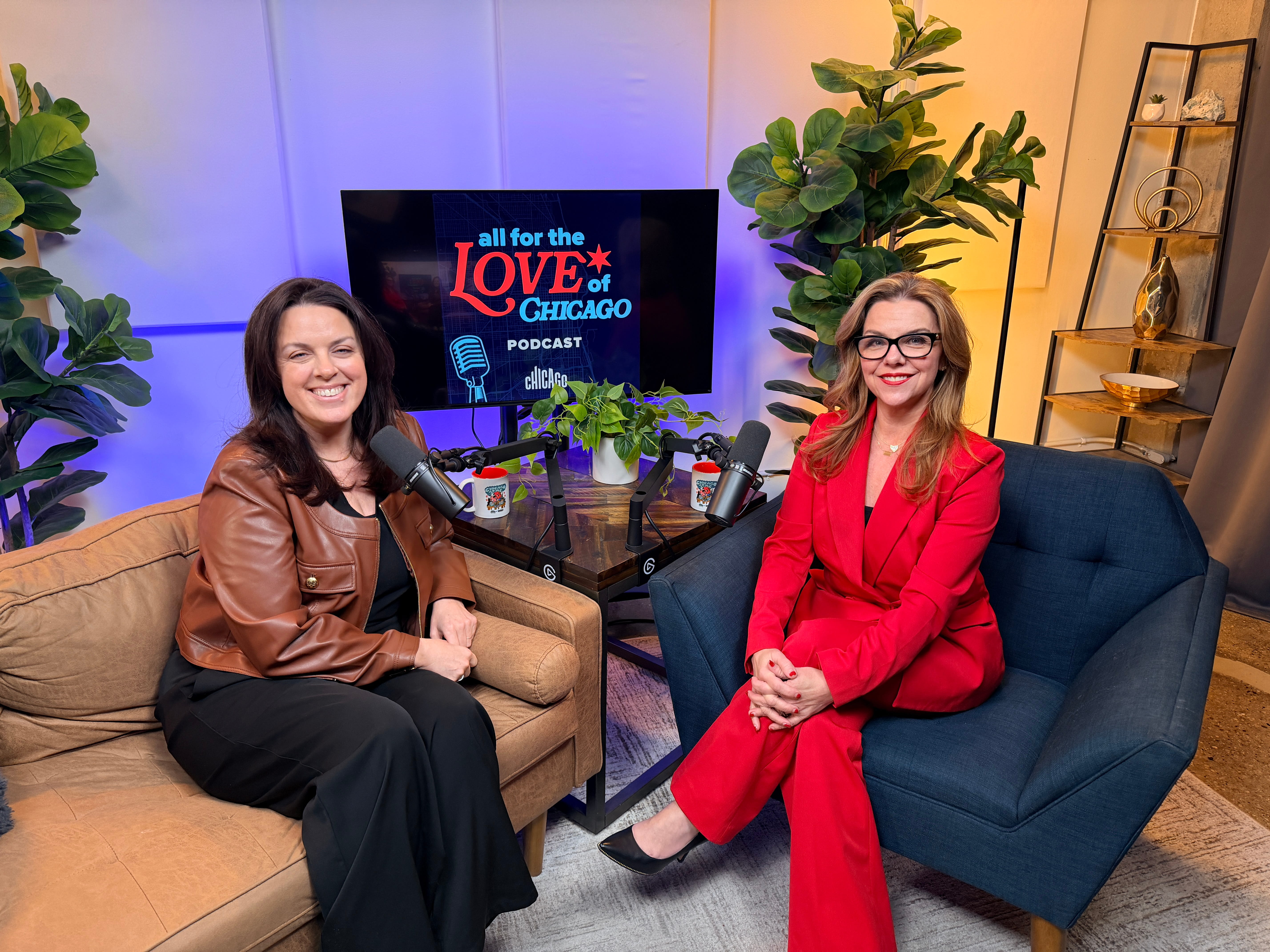 Two people, Choose Chicago CMO Lisa Nucci and Choose Chicago CEO Kristen Reynolds, sitting on a couch and chair with microphones, recording the All for the Love of Chicago podcast.