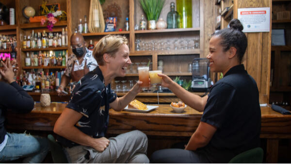 Two people enjoying cocktails at a local women-owned bar