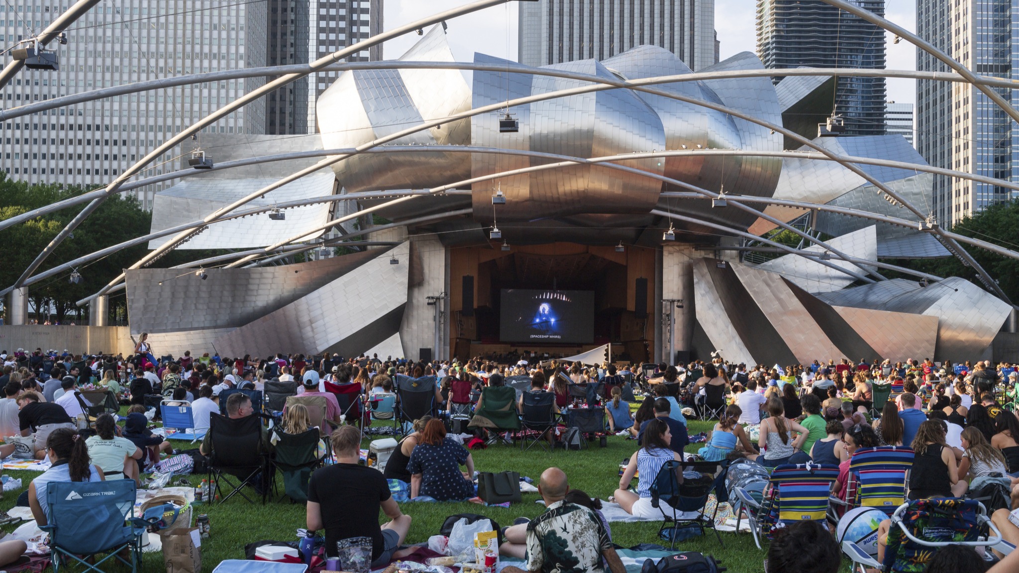 A crowd watches a movie outdoors at Millennium Park