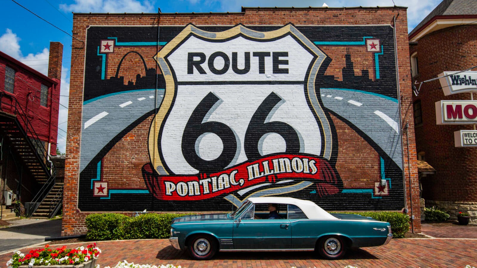 Classic car parked in front of a Route 66 mural
