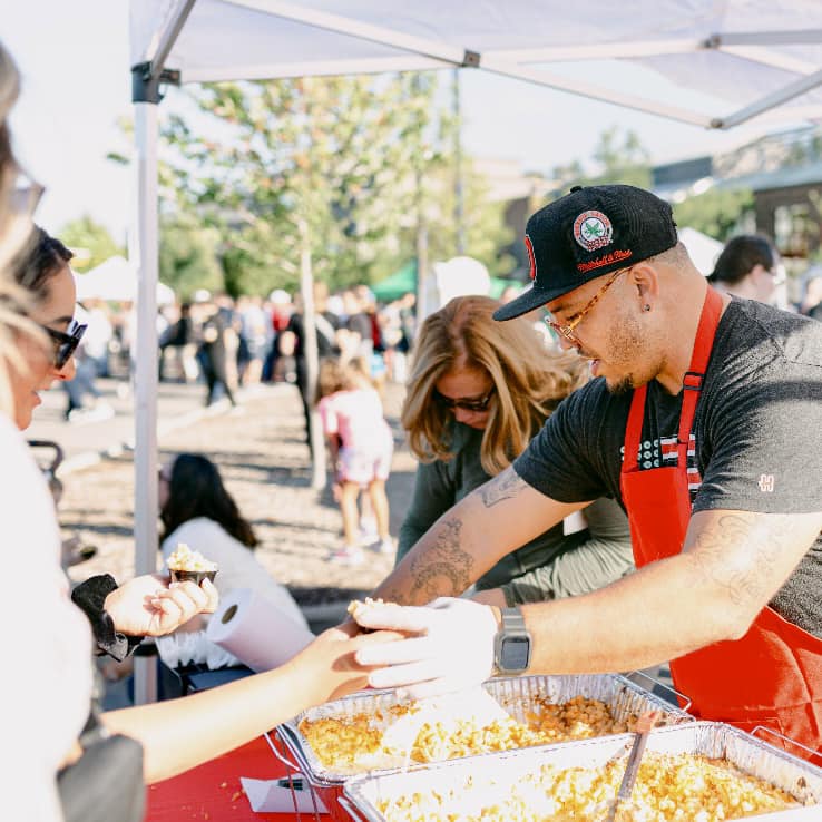 Image of a vendor serving food at Columbus Mac & Cheese Fest