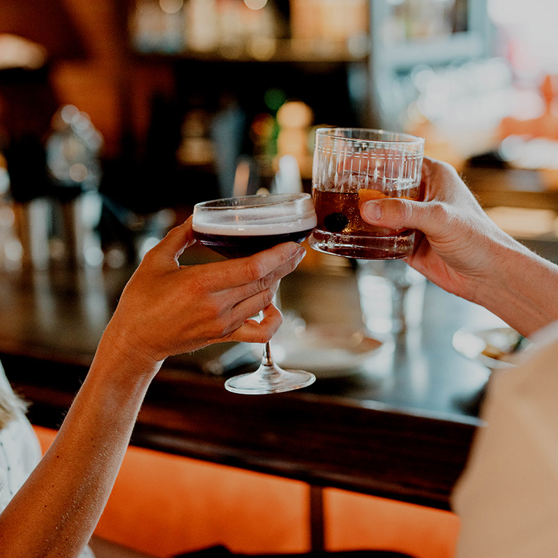 Image of two glasses clinking.