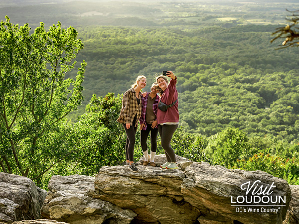 Friends taking a selfie at Bears Den Overlook with a scenic vista as the backdrop.
