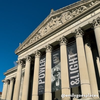 The National Archives building in Washington, DC, with grand columns and banners displaying the ''Power & Light'' exhibition.