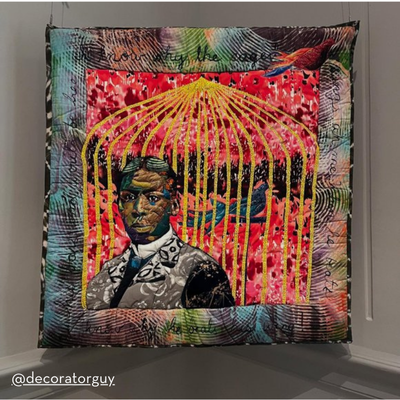 A vibrant textile artwork depicting a portrait of a person in a suit, overlaid with a golden birdcage, set against a colorful patterned background with birds and handwritten text.