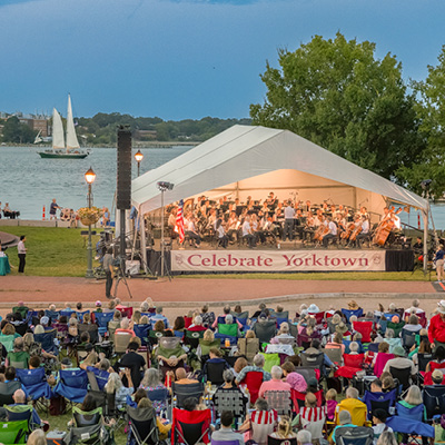 An outdoor summer concert draws a crowd along the York River in Yorktown, Virginia.