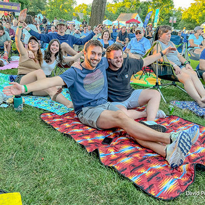Friends gather on picnic blankets to enjoy an outdoor concert in Williamsburg, Virginia.