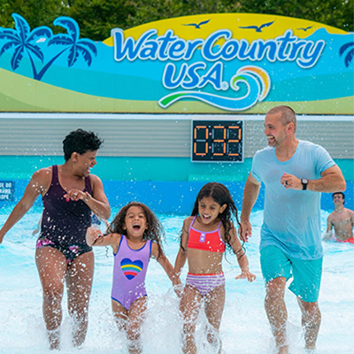 A smiling family walks out of the wave pool at Water Country USA in Williamsburg.