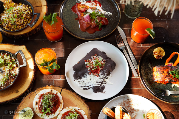 A vibrant Mexican brunch spread at dLeña features tacos, enchiladas, grilled salmon, and cocktails in Washington, DC.