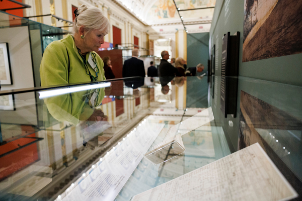A woman examines historical documents displayed in a glass case at the Library of Congress in Washington, DC.
