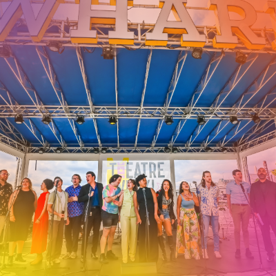 Performers stand on stage under The Wharf sign during Theatre Week in Washington, DC.