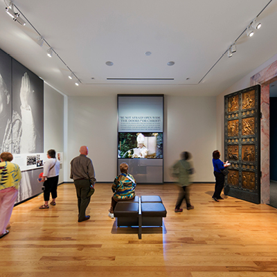 Visitors explore a display about the life of Saint John Paul II in the exhibit at the Shrine.