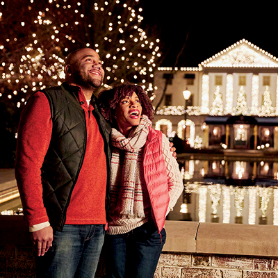 Visitors stroll beneath dazzling holiday lights during Christmas celebrations in Williamsburg.