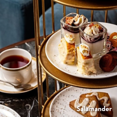 An elaborate high tea spread, complete with festive pastries and a mug of tea. 