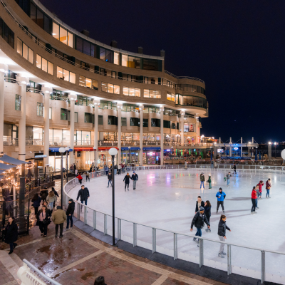 People skate at the Georgetown waterfront ice rink on a clear evening in Washington, DC.