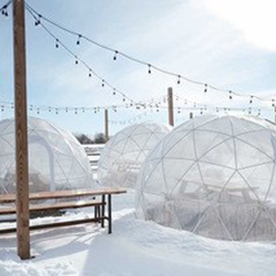 Igloo pods in the snow with string lights at Wheatland Spring Farm & Brewery.