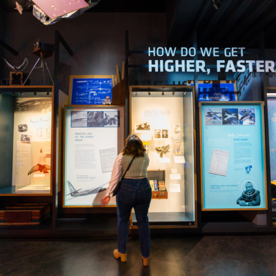 A visitor stands in front of interactive aviation exhibits exploring the history of flight at a museum in Washington, DC.