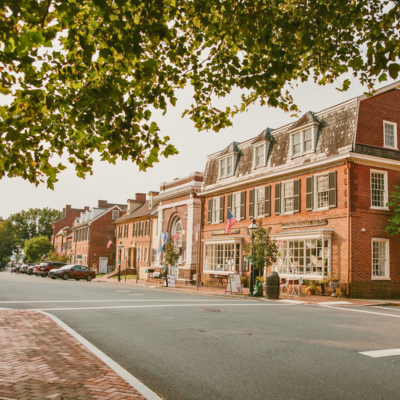 A street in Historic New Castle in New Castle, DE, lined with cobblestone streets and unique shops in historic buildings.