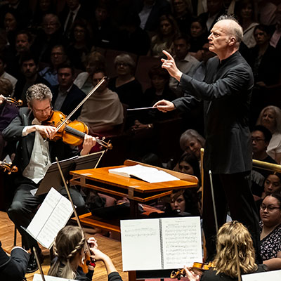 The National Symphony Orchestra performs with audience watching in the background