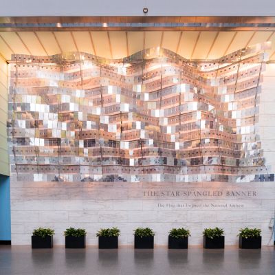 Interior view outside the “Star-Spangled Banner” exhibit at the National Museum of American History, featuring a large abstract flag-inspired installation above the exhibit entrance.