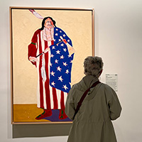 Visitor views “The American Indian” by Fritz Scholder at the National Museum of the American Indian.
