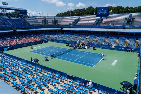 Wide view of the stadium court at the Mubadala DC Open, with tennis players competing before spectators.