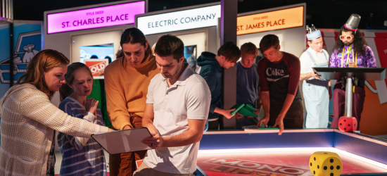 People interacting with a life sized monopoly board