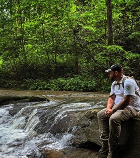 man next to waterfall