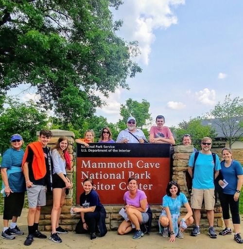 Family posing in front of Mammoth Cave National Park sign