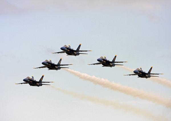 a group of blue jets flying in formation