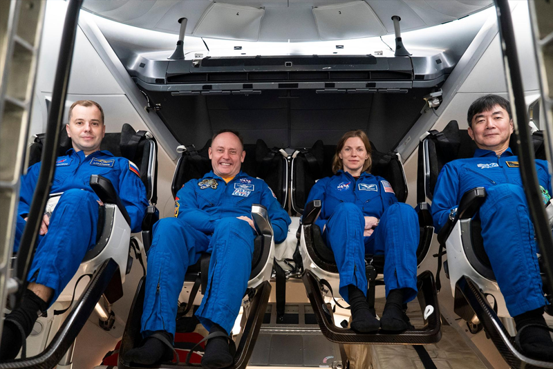 a group of people in blue suits sitting in chairs