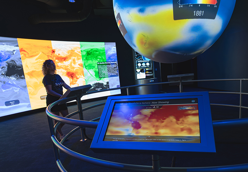 a group of people looking at a large display