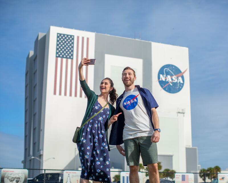 a man and woman taking a selfie in front of a building