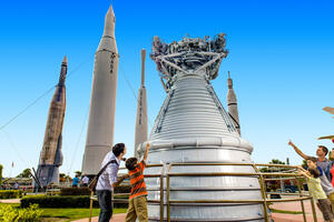 a man and child looking at a rocket