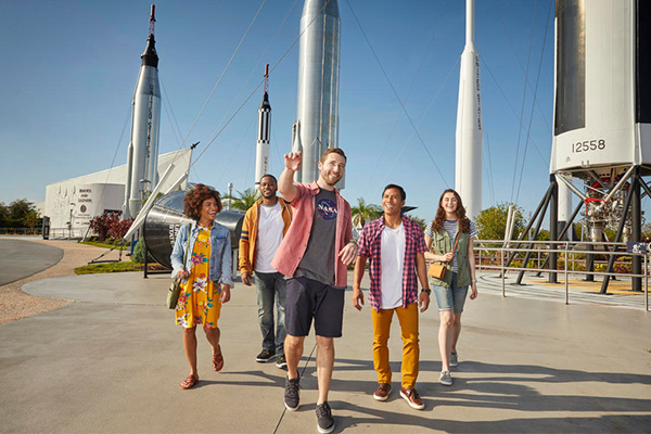 a group of people standing outside with rockets in the background